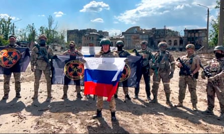 A video screengrab released on Saturday shows Yevgeny Prigozhin, the head of the Wagner group, holding a Russian national flag in front of his soldiers in Bakhmut