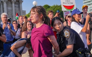A female officer cuffs a female protester