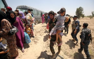 Iraqi forces help families fleeing the fighting on to waiting buses