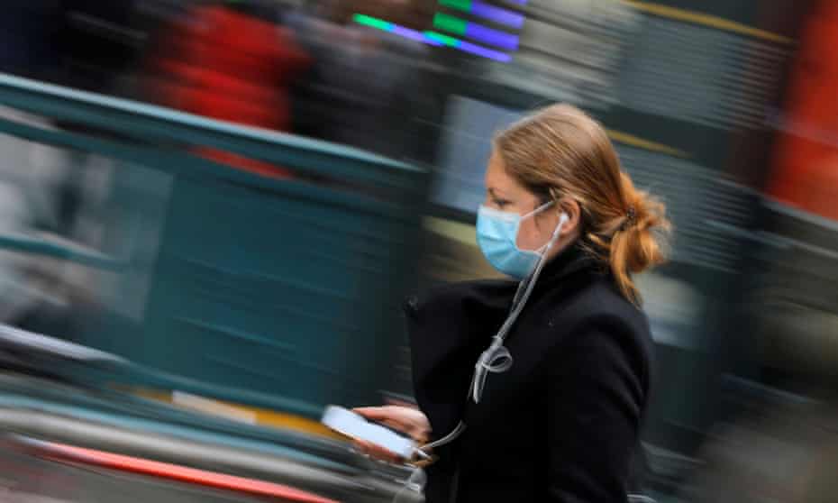 A woman in a face mask walks in New York, New York, on 5 March.