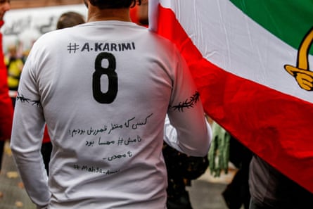 A protester wears a T-shirt emblazoned with Ali Karimi’s name during a demonstration in Germany in 2022