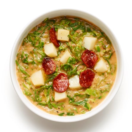 Tampilan atas caldo verde, kentang Portugis, sup bawang dan sosis, dalam mangkuk putih.