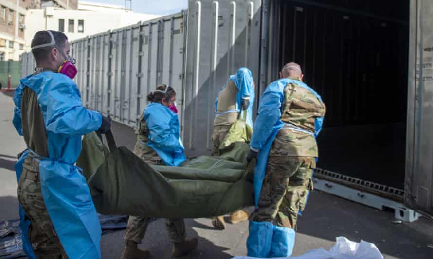 National guard members place the bodies of Covid victims into temporary storage at the medical examiner-coroner’s office in Los Angeles.