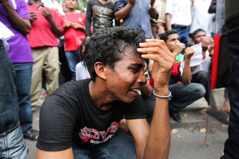 A Rohingya man is upset as people gather around him