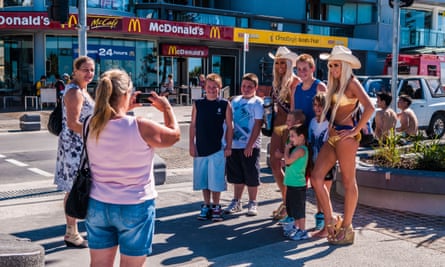 Tourists take a with a pair of Gold Coast ‘meter maids’. They feed the parking meters of those who overstay so drivers can spend more time in the resort.