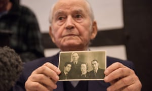 Auschwitz survivor Leon Schwarzbaum presents an old photograph showing himself next to his uncle and parents who all died at the death camp.