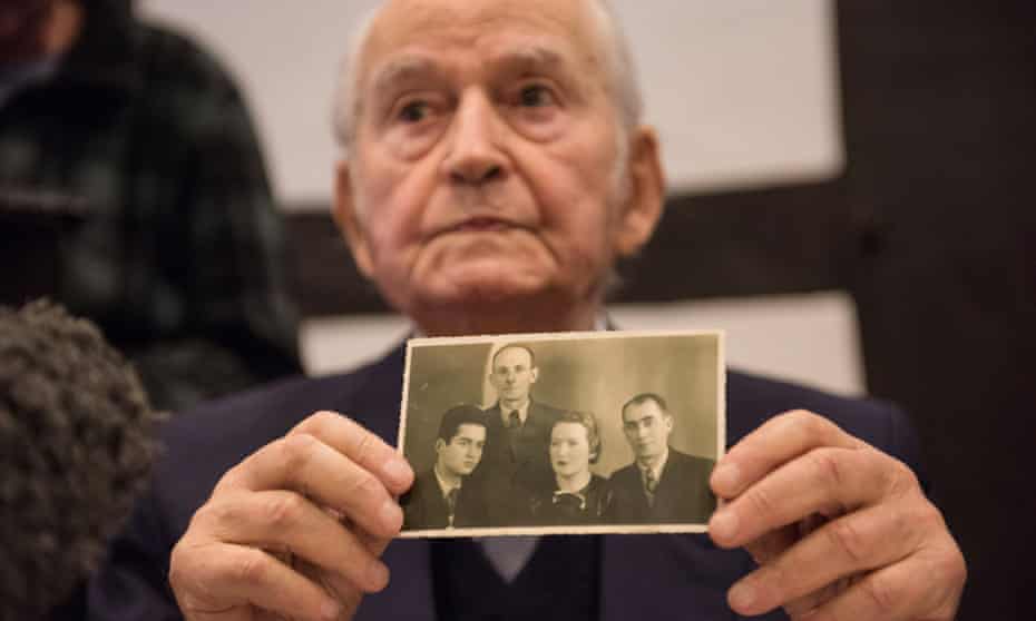 Auschwitz survivor Leon Schwarzbaum holds a photograph of family members who were killed during the second world war.