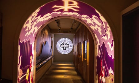 A corridor of the Faith Museum with a cross on the far wall