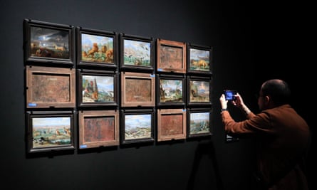 A visitor takes pictures of works on display at the Prado exhibition.