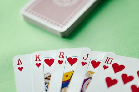 Cards showing a royal flush poker sequence on a green table