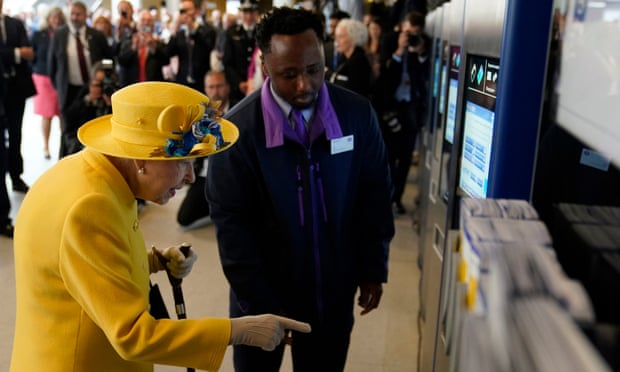 The Queen using an Oyster card machine at Paddington station.