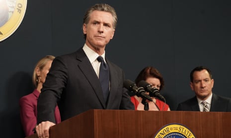 Gavin Newsom stands in front of a lectern bearing the seal of the governor of California.