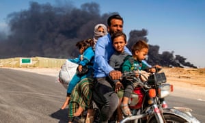 People leave an area near the Syrian Kurdish town of Ras al-Ayn