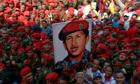 Soldiers holds a portrait of late Venezuelan president Hugo Chavez