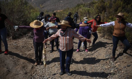 Relatives of the disappeared form a human chain to comb a suspected clandestine burial ground in the Mexican town of Ensenada last month Photograph: Emilio Espejel/The Guardian