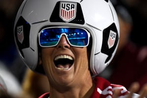 A fan wears a giant soccer ball helmet