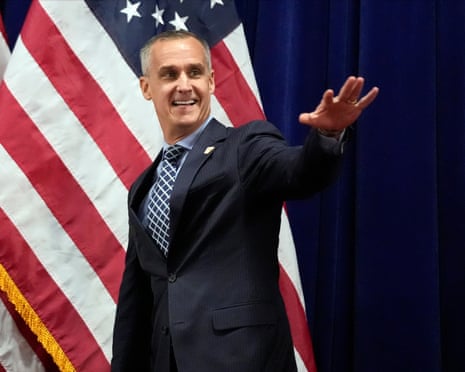 Corey Lewandowski in front of a US flag.