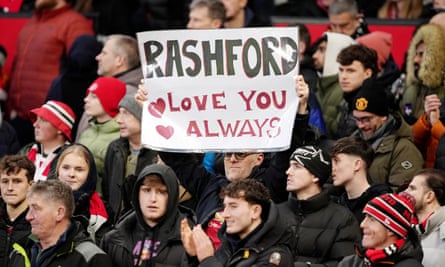 A Manchester United fan holds a sign that says ‘Rashford, love you always’.