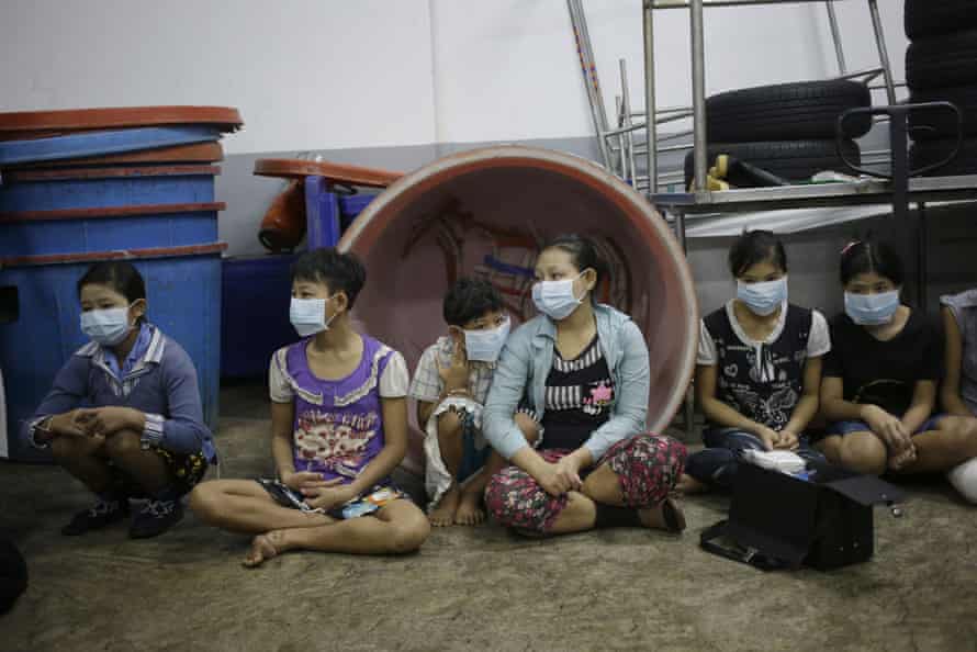 Children and teenagers sit together to be registered by officials during a raid on a shrimp shed in Samut Sakhon, Thailand, 9 November 2015