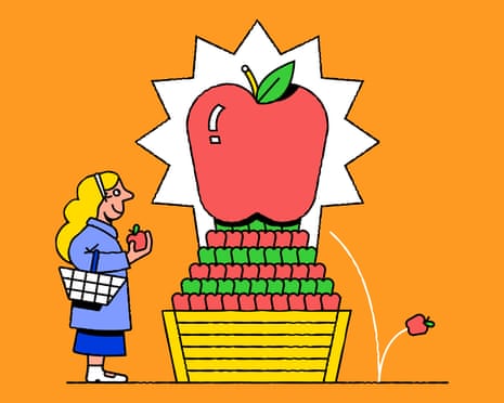 A woman with a shopping basket looks at a large pyramid display of apples with a giant apple on top