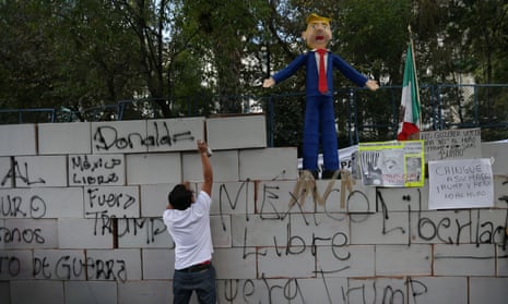 An effigy of Donald Trump stands on a symbolic wall built by protesters outside the US embassy in Mexico City.
