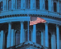 A US flag flies in front of a government building