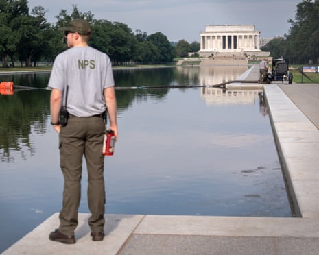 A National Park Service worker stands near a pump placed next to the Lincoln Memorial Reflecting Pool.