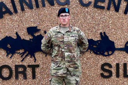 a man in a soldier’s uniform stands with his hands behind his back