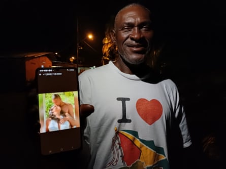 a man holds a device showing a photograph of two people