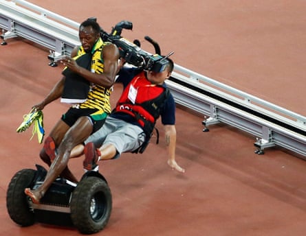 A Tv cameraman drives into Usain Bolt of Jamaica after the men’s 200m final during the Beijing 2015 IAAF World Championships