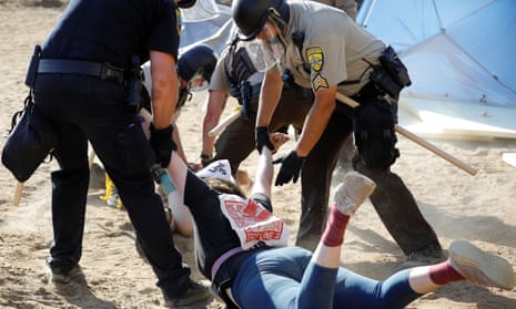 Police officers drag a demonstrator who was protesting at an Enbridge pump station construction site in Hubbard county, Minnesota, 7 June 2021. 