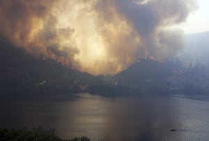 A forest fire rages on hills across the Tagus river on 27 July, near Vila Velha de Rodao, central Portugal.