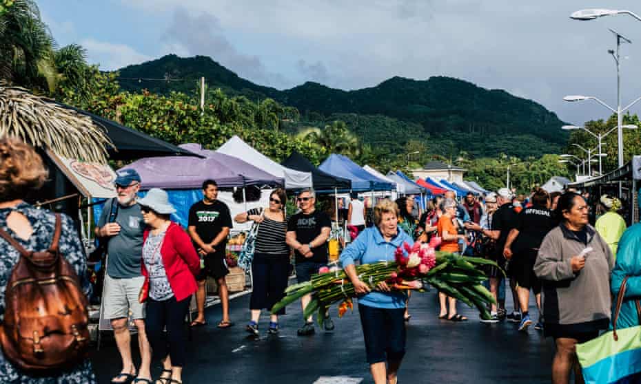 Tourists mix with locals at a market in Rarotonga, Cook Islands.