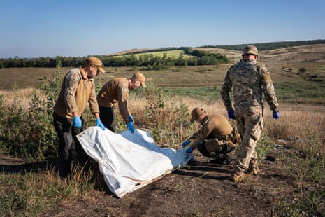 Members of the Platzdarm search team prepare a body bag to be taken away.