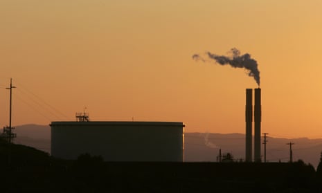 An oil refinery is seen at sunset.