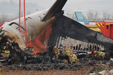Firefighters conduct search operations at the crash site