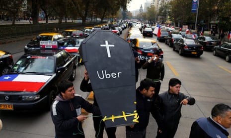 Taxi drivers carry a fake coffin as they block a street during a protest against Uber in Santiago, Chile, May 2016. 
