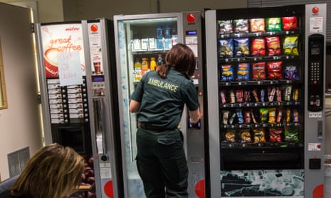 An ambulance worker gets some refreshments from a vending machin