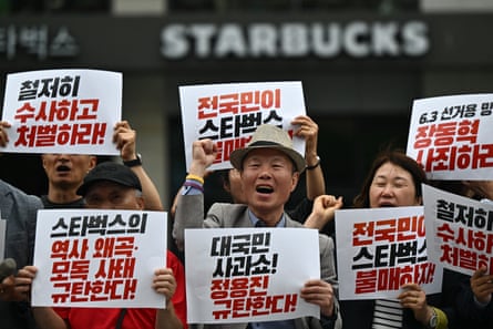 Activists protesting Starbucks hold placards