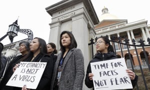 Jessica Wong, front left, Jenny Chiang, center, and Sheila Vo from the Massachusetts’ Asian American Commission, stand together during a protest on 12 March.
