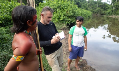 Dom Phillips talks to two indigenous men in Aldeia Maloca Papiú, Roraima state, Brazil, in 2019.