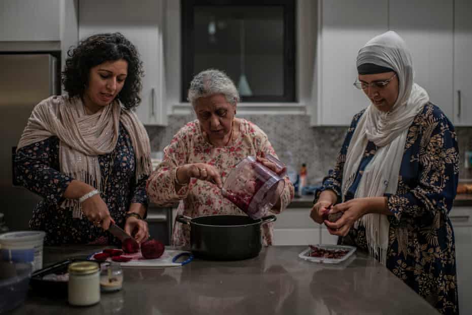 Three woman preparing a meal in a kitchen