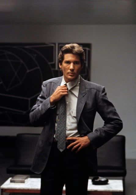 Richard Gere wearing a grey suit and loosening his tie