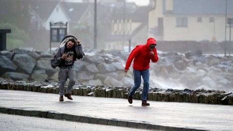 伊莎风暴期间，戈尔韦索尔特希尔的人们在强风中行走。