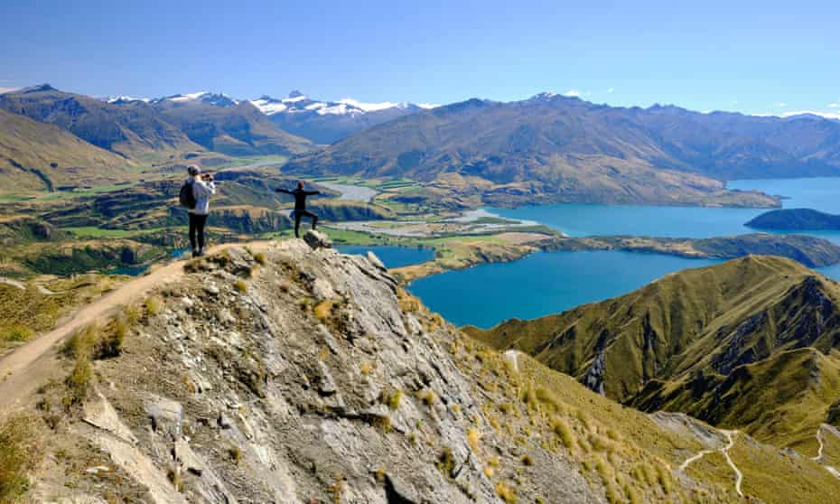 Tourists taking pictures of the views of Lake Wanaka from Roy's peak. Otago, South Island, New Zealand. 