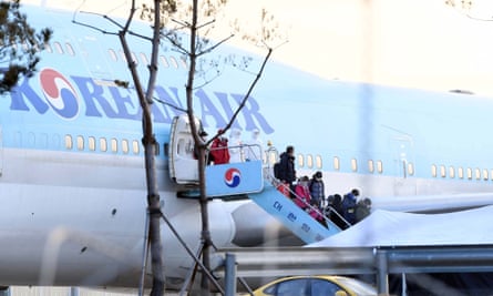 People disembark from South Korea’s first evacuation plane, carrying 367 nationals, from Wuhan.