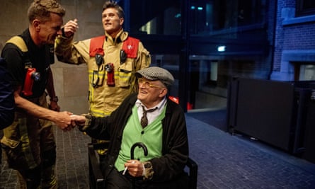 David Hockney, cigarette in hand, poses with his rescuers after he was stuck in an elevator in the Conservatorium Hotel in Amsterdam for almost half an hour.