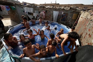 Children play in an outdoor pool in Manshiyat Naser, Cairo
