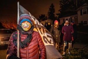A woman holds a Black Lives Matter flag as she participates in a call to action White People Stop Calling the Cops on Black People protest hosted by Showing Up for Racial Justice Columbus(SURJ) in front of the house of the neighbour who called the police on Andre Hill the night he was shot and killed in Columbus, Ohio