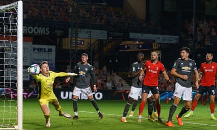 Manchester United goalkeeper Dean Henderson claws the ball away after a header by Tom Lockyer of Luton Town.